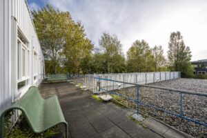 Dakterras met zitbanken en uitzicht op bomen bij Van der Madeweg.